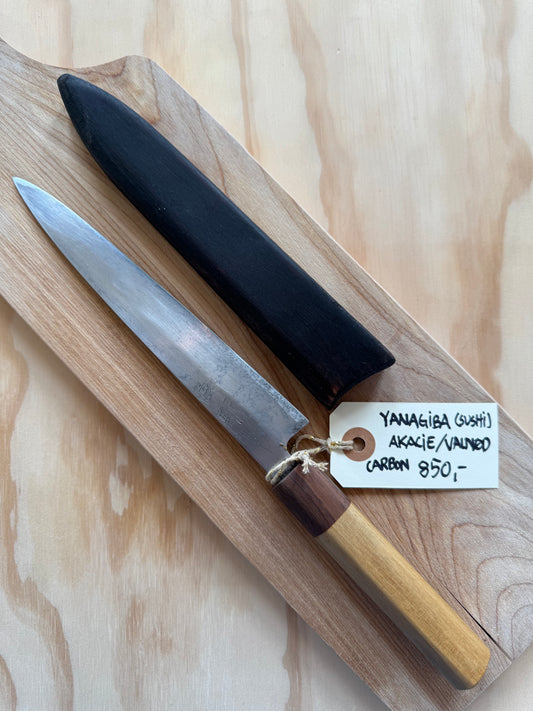 Yanagiba (sushi/sashimi kniv) i Carbon med akacie fra sygt træ fra Vejle og valnød fra Aarhus. Yakisugi custom saya følger med. Japansk leverandør spår klingen til +40 år. 